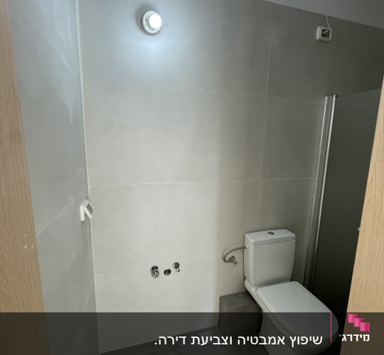 חדר שירותים עם אסלה וקירות חדשים